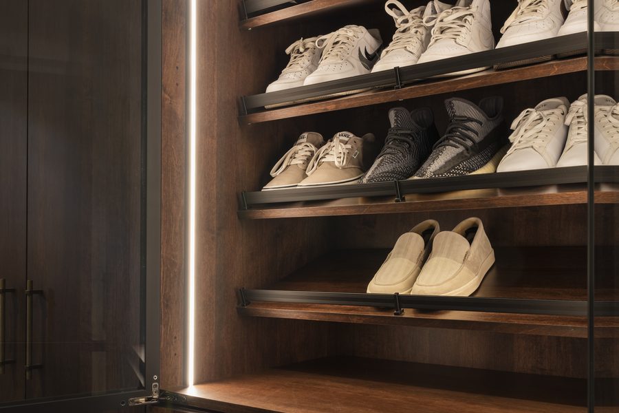 Custom walk-in wardrobe with glass-front shoe display by Pro-Con Construction