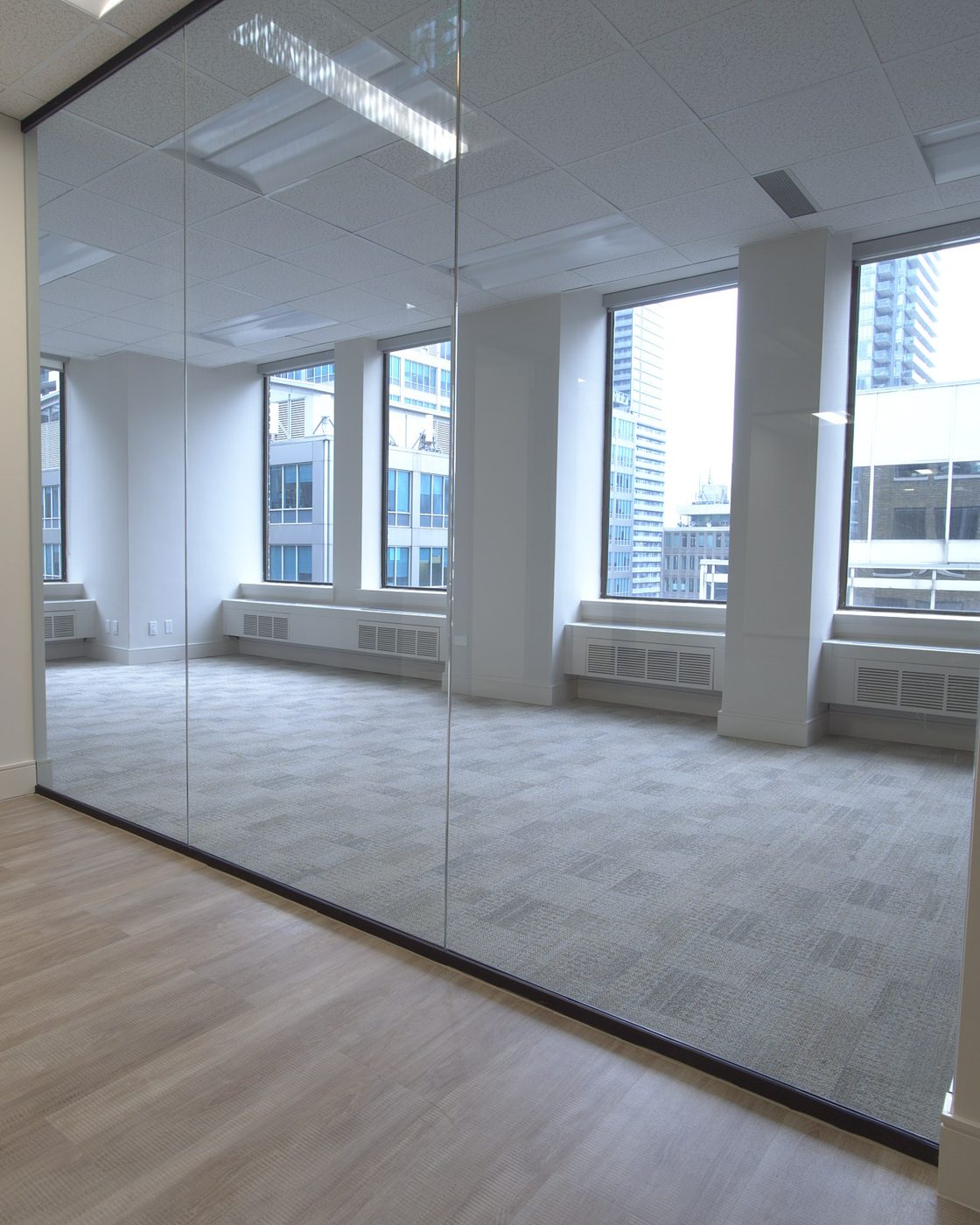 Glass partition wall and window wall with downtown Toronto skyline — commercial office fit-out by Pro-Con Construction